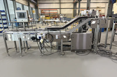Industrial food processing equipment with conveyor systems and stainless steel machinery in a manufacturing facility warehouse.