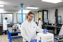 Scientist in white lab coat working with 3D printer equipment in modern laboratory facility