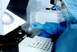 Laboratory technician in protective gear handling samples in a biosafety cabinet during scientific research