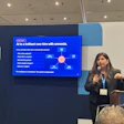 Professional woman presenting at conference with AI diagram on screen behind podium